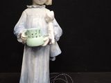 a figurine of a little girl holding a bowl