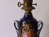 a blue vase lamp with a gold base and a floral design on it