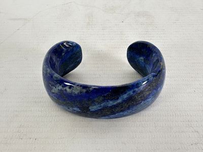 lapis bracelet with a blue marbled surface on a white surface