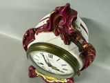 a white and red clock with gold accents on it