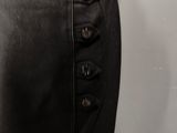 the skirt is made of black leather and has buttons on the side