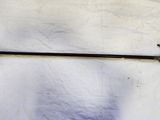 un long bâton muni d'un manche, accroché à un mur blanc