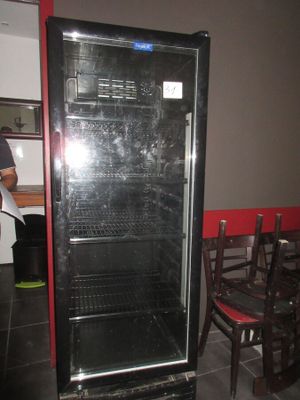 une photo d'un réfrigérateur dans une cuisine avec une table et des chaises