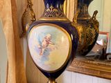 a blue vase sitting on a table with a mirror in the background