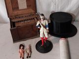un chapeau, un haut-de-forme, une poupée et d'autres objets posés sur une table