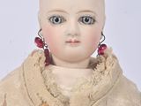 a doll that is sitting on a white surface