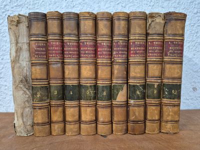 six old books sitting on top of each other on a table