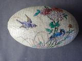 a decorative stone with a bird and flowers painted on it