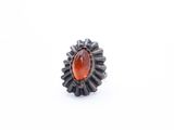 a close up of a ring with an orange stone in it