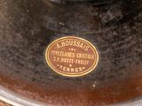 a close up of a brown vase with a label on it