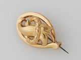 an image of a gold broochle with a dragon on it
