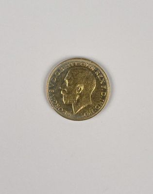 gros plan d'une pièce d'or sur une surface blanche