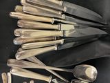 beaucoup de cuillères en argent et de cuillères à soupe sur une table