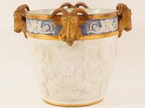 a white vase with a blue and gold decoration on it
