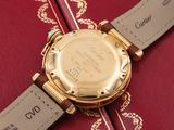 a close up of a gold watch on a red book