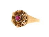 gros plan d'une bague en or avec une pierre en rubis