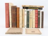 several old books are stacked on top of each other on a white surface