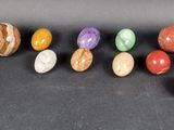 a group of seven different colored stones sitting on top of a table