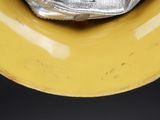a yellow plate with a silver object on top of it