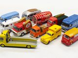 many different types of toy cars and trucks on a white surface