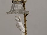 an antique lamp with a glass shade and a statue on it