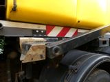 a close up of a yellow and black truck on the road