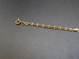 a close up of a gold chain bracelet on a black surface
