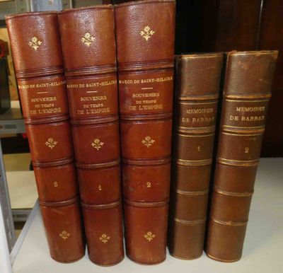 plusieurs vieux livres sont alignés sur une étagère dans une bibliothèque