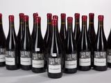 six bottles of wine lined up in a row on a white surface