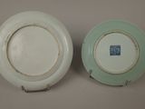 pair of green and white plates with a blue and white design on them
