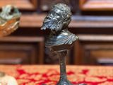 une statue représentant un homme assis sur une table, à côté de coquillages