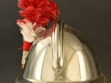 a silver helmet with a red flower on top