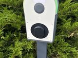 a parking meter with a sign on it in front of a bush