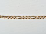 a close up of a gold chain on a white surface