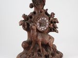 a wooden clock that has a deer and a tree on it