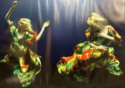 tableau représentant deux femmes en robes colorées qui dansent dans l'eau