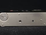 a close up of a silver electronic device on a black surface