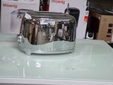 un grille-pain argenté posé sur une table en verre