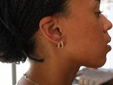a woman that is wearing a pair of earrings