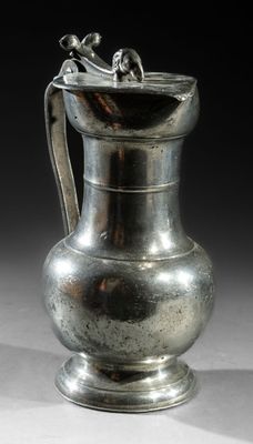 a silver vase that is sitting on a table