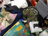 a pile of clothes and books on a bed