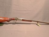 gros plan d'un fusil avec une poignée en bois sur fond blanc