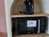 un micro-ondes posé sur une étagère dans un coin de la pièce