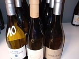 several bottles of wine are lined up on a counter