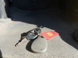 a car key laying on the floor next to a rock