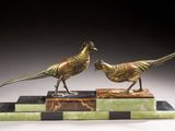 pair of bronze pheasants on marble base on black background