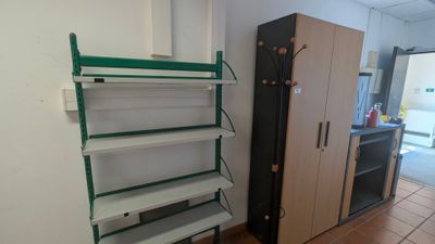 une étagère dans un coin d'une pièce, avec un réfrigérateur en arrière-plan