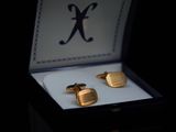 a box with two cufflinks in it and a ring in it