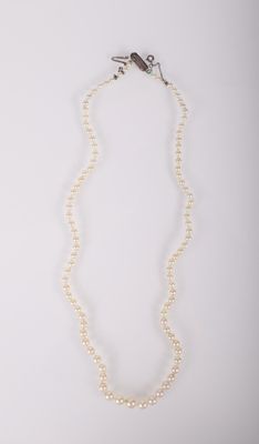 un collier de perles blanches avec un fermoir en argent sur fond blanc
