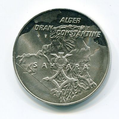 un gros plan d'une pièce d'argent sur laquelle figure l'effigie d'un homme